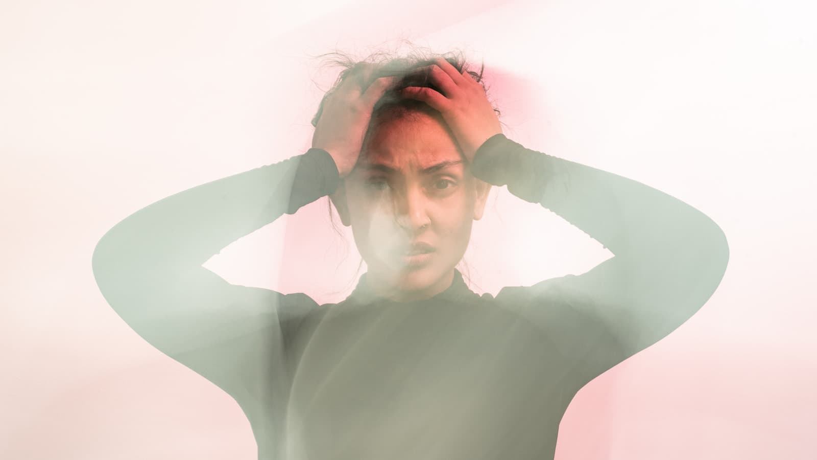 A woman with her hands in her hair, caught mid-motion