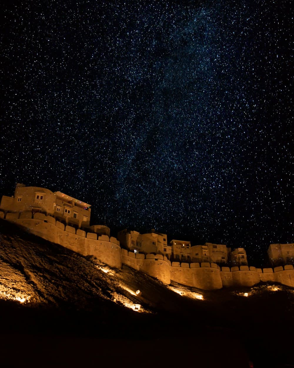 A fort lit against a sky full of stars