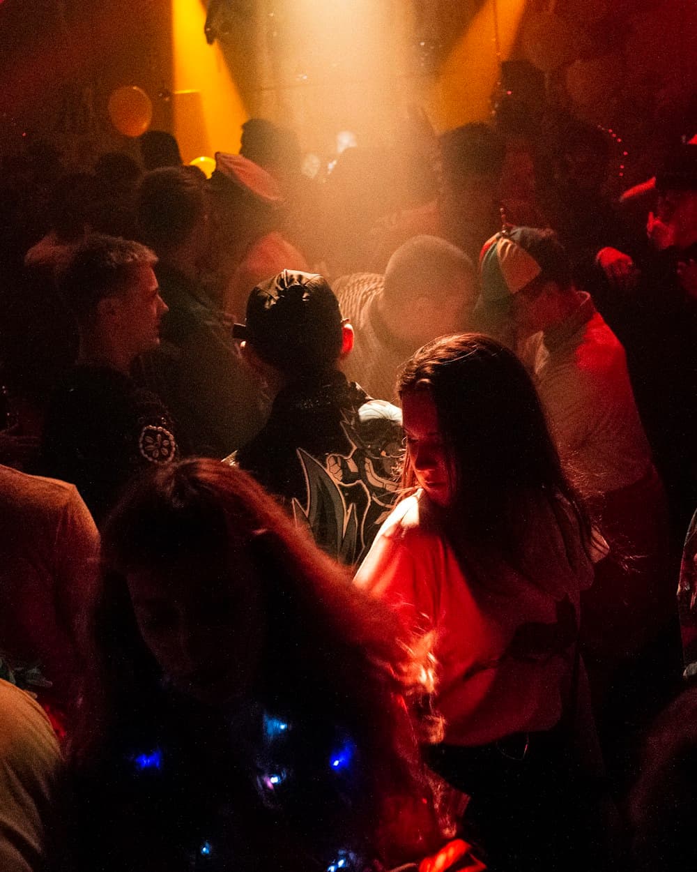 A crowd close together at a gig, lit warm